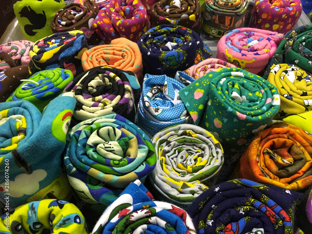 Multicolored rolls of cotton fabric in assortment on market