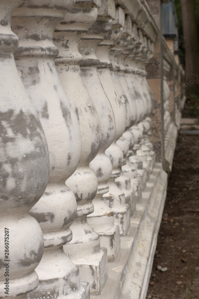 Antique balusters of gray color with cracked white paint. Linear perspective. Creative vintage background. Balustrade. Antique balusters of gray color with cracked white paint. Linear perspective. Creative vintage background. Balustrade.