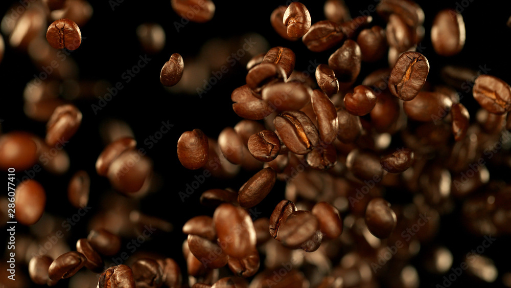 Fresh roasted coffee beans flying in the air Fresh roasted coffee beans flying in the air