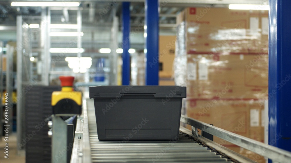 E-commerce. Plastic Box moving on conveyer belt in Distribution Warehouse E-commerce. Plastic Box moving on conveyer belt in Distribution Warehouse