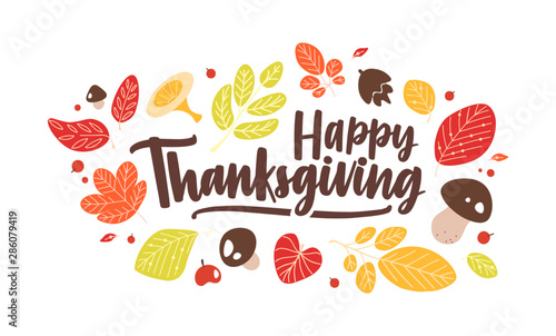 Happy Thanksgiving phrase handwritten with elegant calligraphic script and decorated by fallen autumn leaves and mushrooms