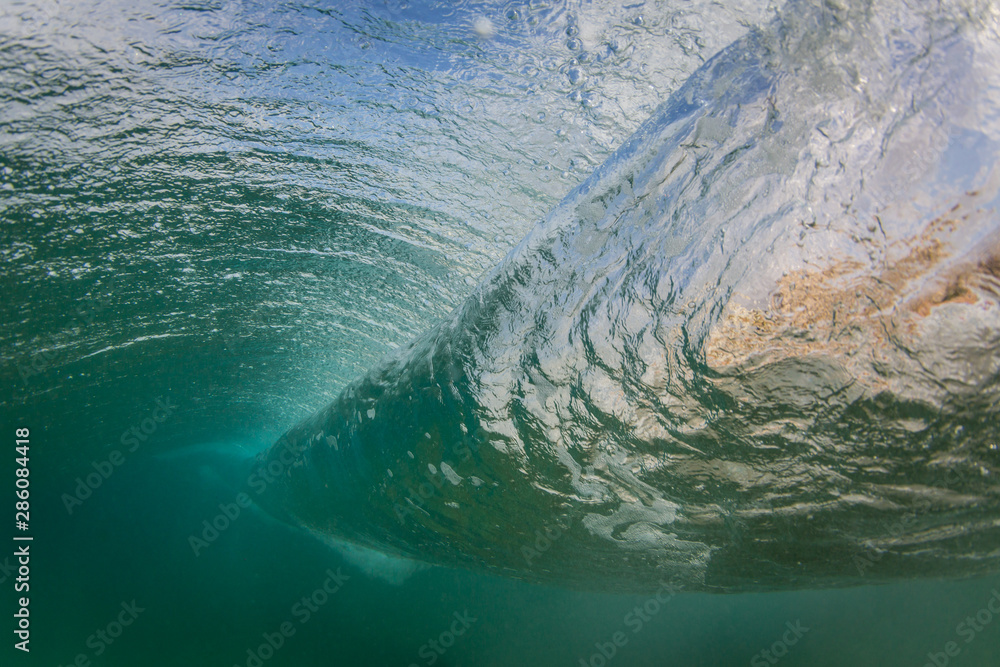 underwater scene of a breaking wave in the ocean