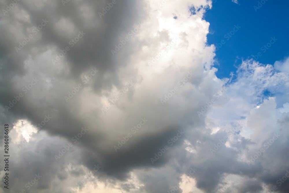 Cumulus clouds gather before the rain against a clear blue sky. Natural landscape.