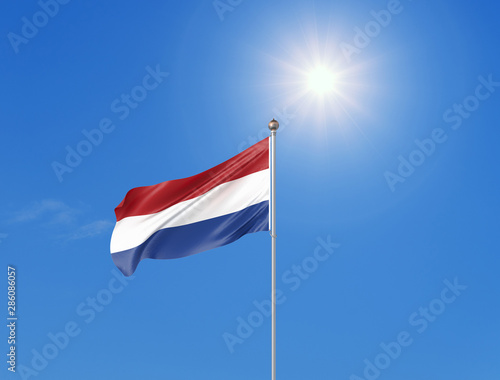 3D illustration. Colored waving flag of Netherlands on sunny blue sky background.