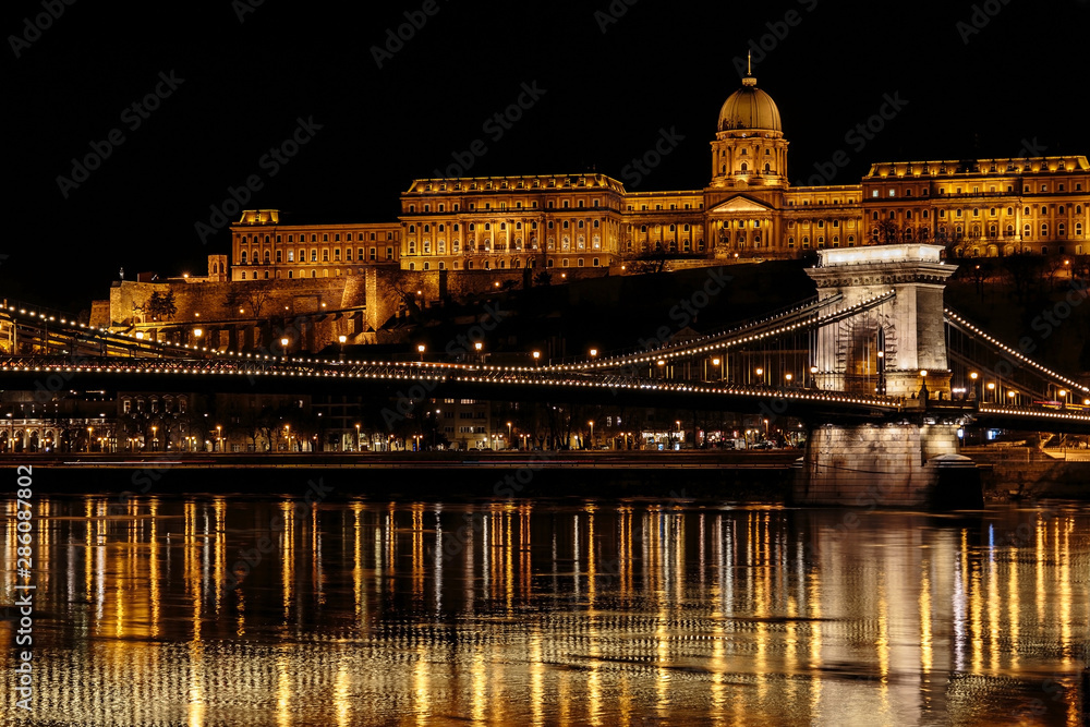 Szechenyi Chain bridge over Danube river in Budapest with the Buda castle on the background, night illumination