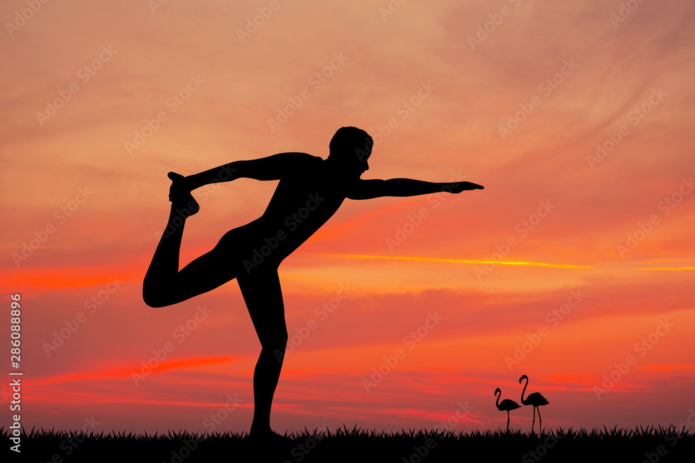 man doing yoga at sunset