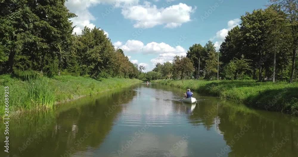 Two people on a boat floating on the river. Two people on a boat floating on the river.