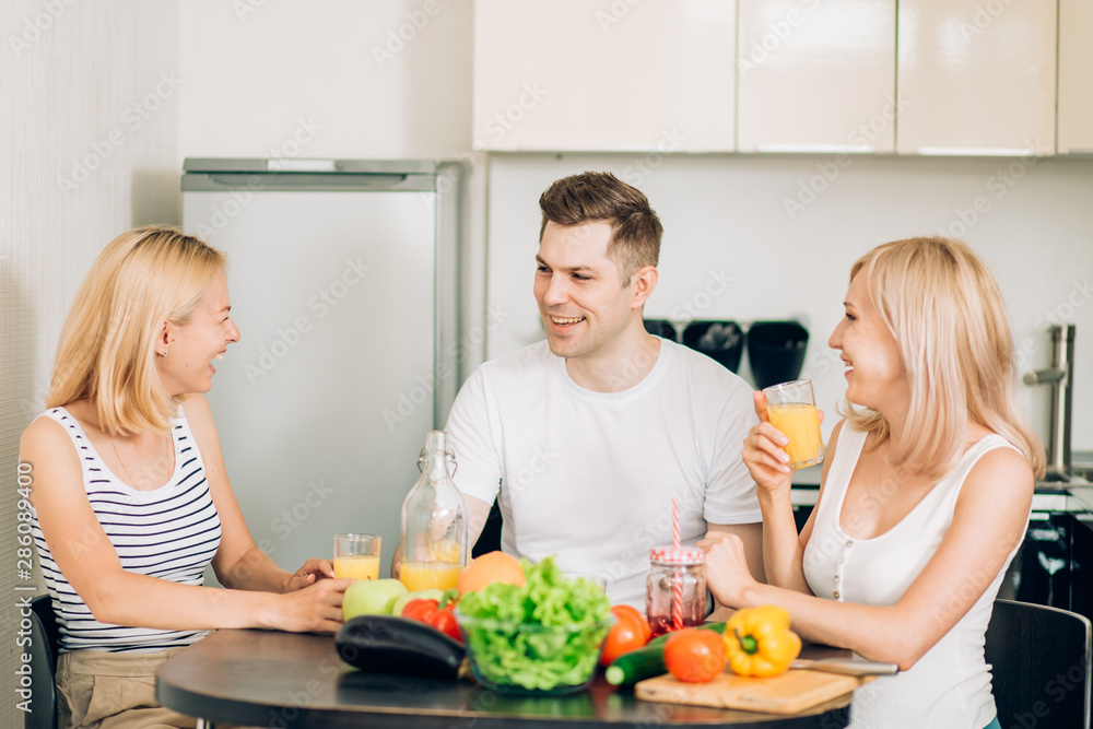 Friends sitting at table in kitchen