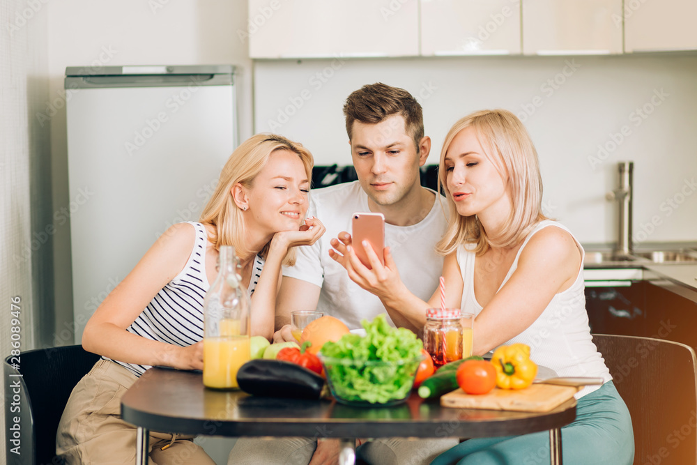 Friends sitting at table in kitchen Friends sitting at table in kitchen