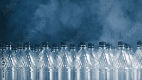 empty plastic bottles on black background with smoke  pollution concept