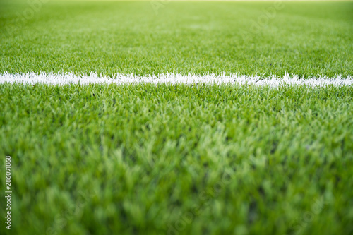 Texture of artificial grass herb cover sports field. It is used in different sports: football, tennis, baseball, soccer, american football, cricket, golf, field hockey, rugby.