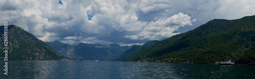 View of Boko Kotor on the background of mountains with clouds in the sky on a sunny day. © StockAleksey