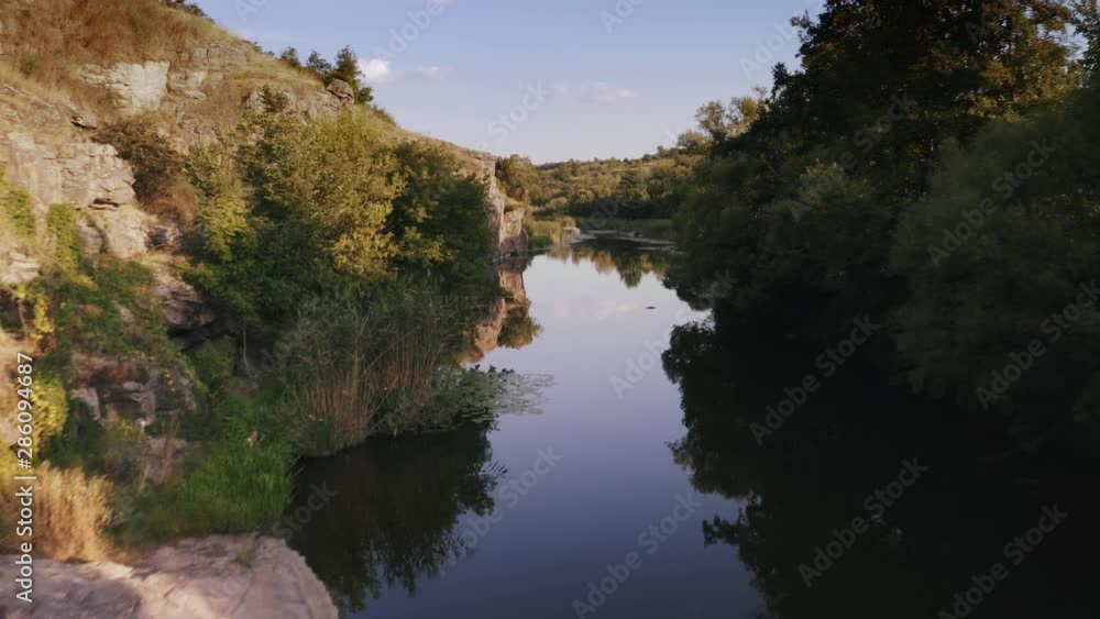 Aerial shot with drone flying close to the water in canyon during sunny day Aerial shot with drone flying close to the water in canyon during sunny day