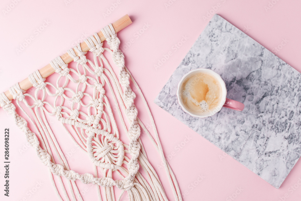 Creative flat lay concept, coffee cup on marble plate and macrame on pastel pink background and copy space, minimal style, saint valentine romance trendy composition Creative flat lay concept, coffee cup on marble plate and macrame on pastel pink background and copy space, minimal style, saint valentine romance trendy composition