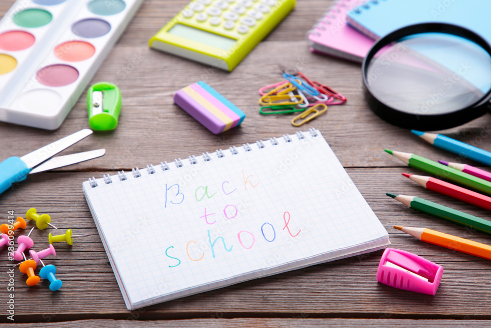 Inscription Back To School with school supplies on grey wooden background Inscription Back To School with school supplies on grey wooden background