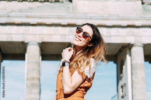  walk around Berlin with a blogger. smiling girl traveler at the Brandenburg gate.