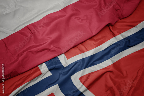 waving colorful flag of norway and national flag of poland.