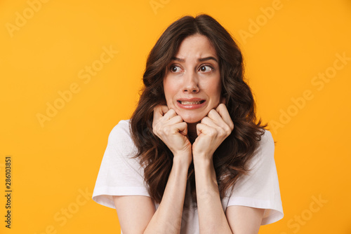 Fotografie Image of nervous woman with long dark hair frowning and expressing fear