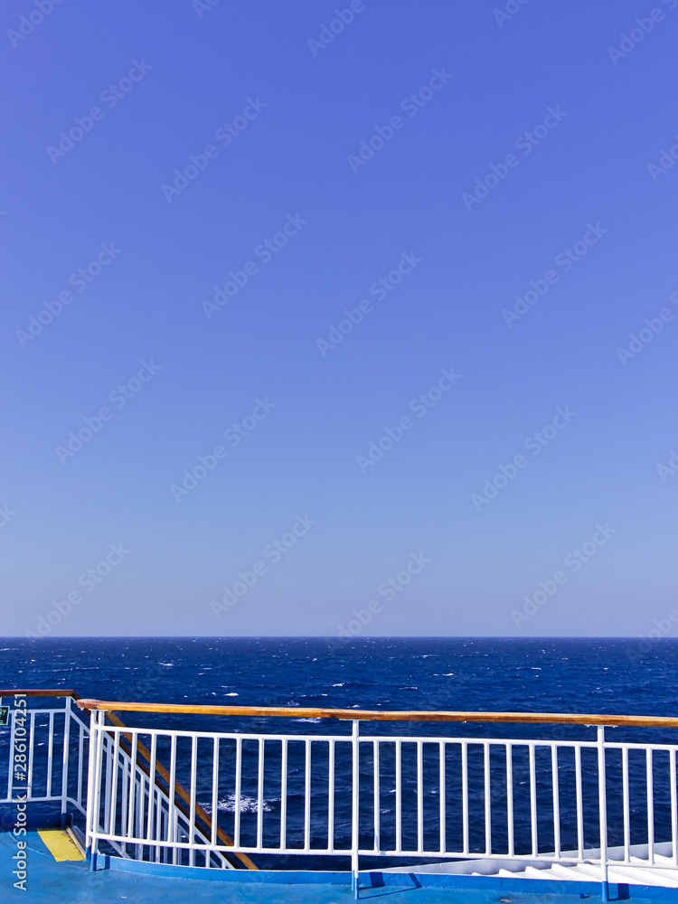 Ship railing and deck while wailing on open sea.