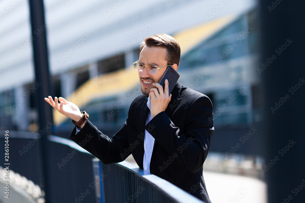 Businessman in a rage shouts at mobile phone outside, upset, hate. Businessman in a rage shouts at mobile phone outside, upset, hate.