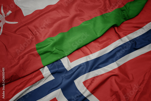 waving colorful flag of norway and national flag of oman.