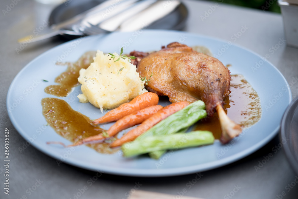 Duck leg confit with potato and vegetable. Duck leg confit with potato and vegetable.