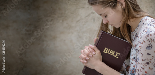 Christian worship and praise. A young woman is praying and worshiping in the evening.