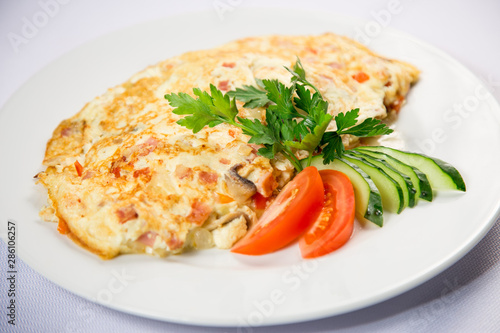 fried eggs and omelet with vegetables on a white background