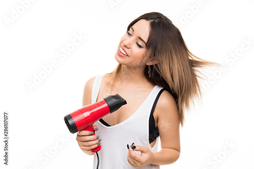 Young woman over isolated white background with hairdryer