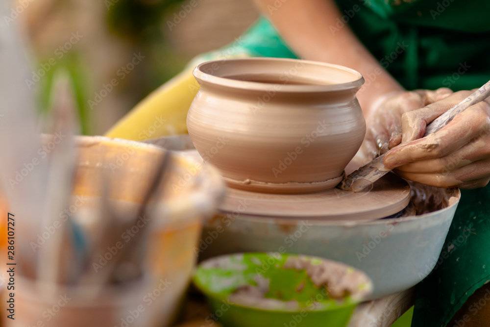 Hand craft making pottery on wheel. Female hands mold ceramic plate from clay (pot). Hand craft making pottery on wheel. Female hands mold ceramic plate from clay (pot).