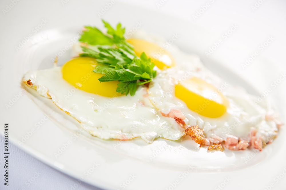 fried eggs and omelet with vegetables on a white background fried eggs and omelet with vegetables on a white background