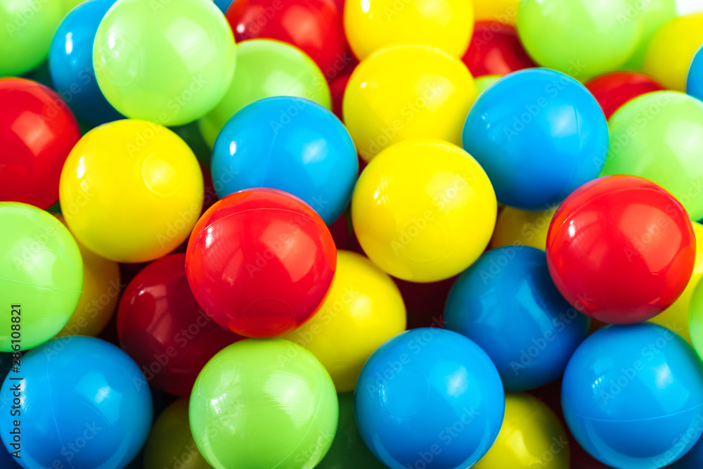 Colored plastic balls in pool of game room. Dry Swimming pool for fun and jumping in colored plastic balls. The concept of celebration and fun Colored plastic balls in pool of game room. Dry Swimming pool for fun and jumping in colored plastic balls. The concept of celebration and fun
