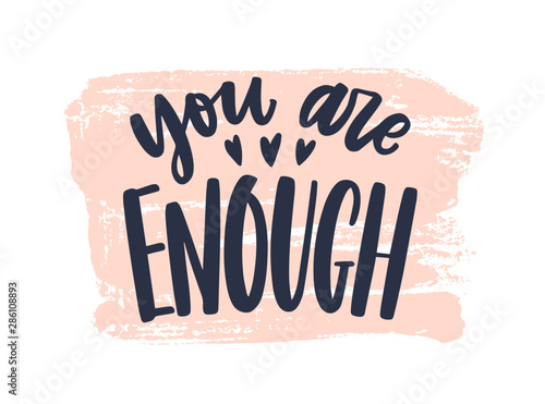 You Are Enough phrase handwritten with stylish cursive calligraphic font or script on paint trace