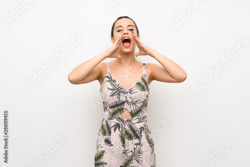Young woman over isolated white background shouting and announcing something