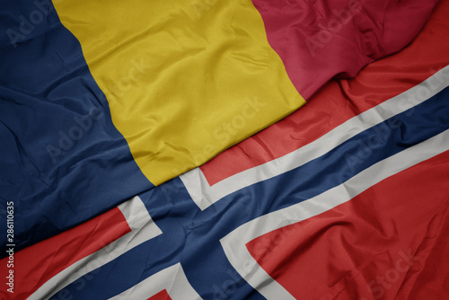 waving colorful flag of norway and national flag of chad.