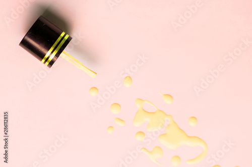 Nail polish bottle and drops on white background