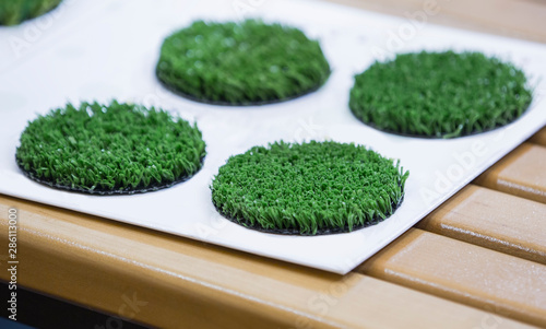 Green artificial turf rolled. Probes examples of artificial turf, floor coverings for playgrounds. Selective focus