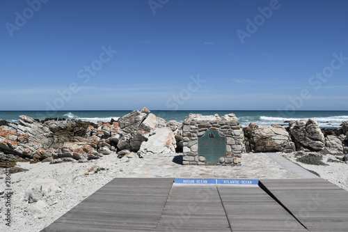 plaque at southernmost point of Africa against Atlantic Ocean and Indian Ocean at Cape Agulhas on sunny day