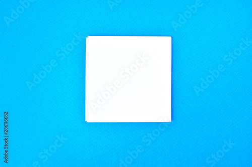 Empty white paper on a blue background, as mockup for your design. Minimal composition in flat lay style.