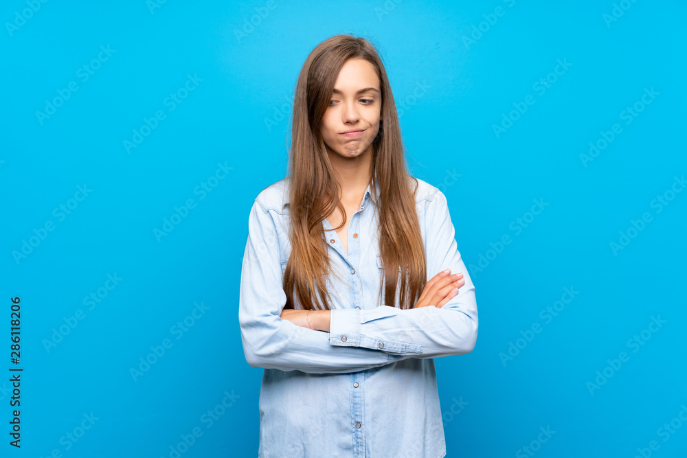 Young woman over isolated blue background feeling upset Young woman over isolated blue background feeling upset