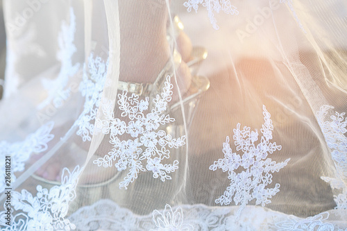 Closeup wedding dress with woman leg and wedding shoe inside. wedding concept.
