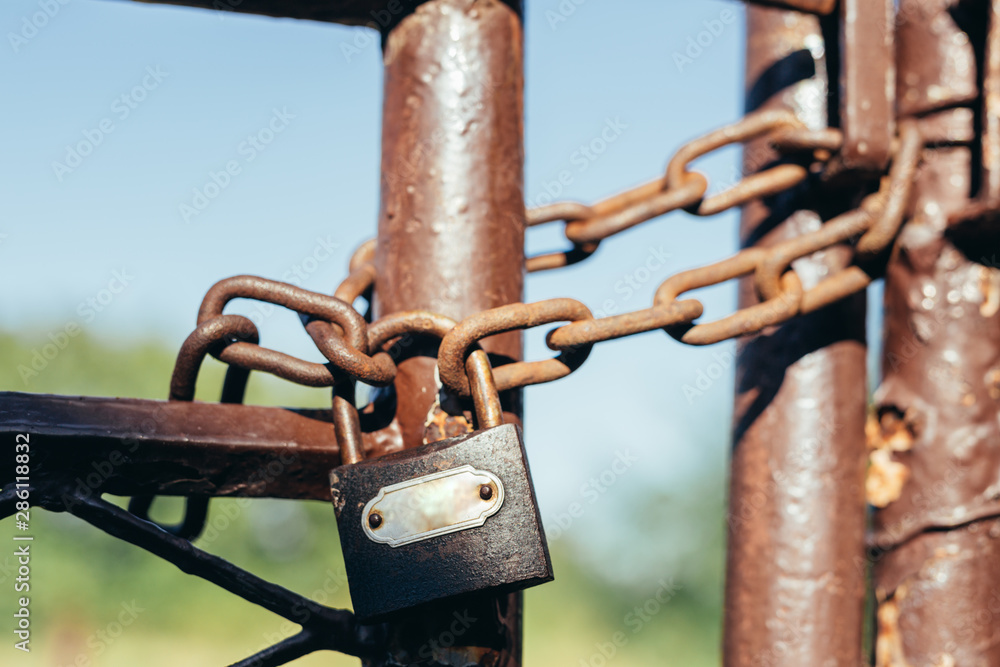 padlock locked on rustic door with chain outdoors padlock locked on rustic door with chain outdoors