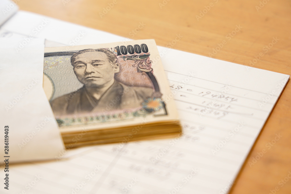 Obraz premium 手書きの家計簿と日本のお金