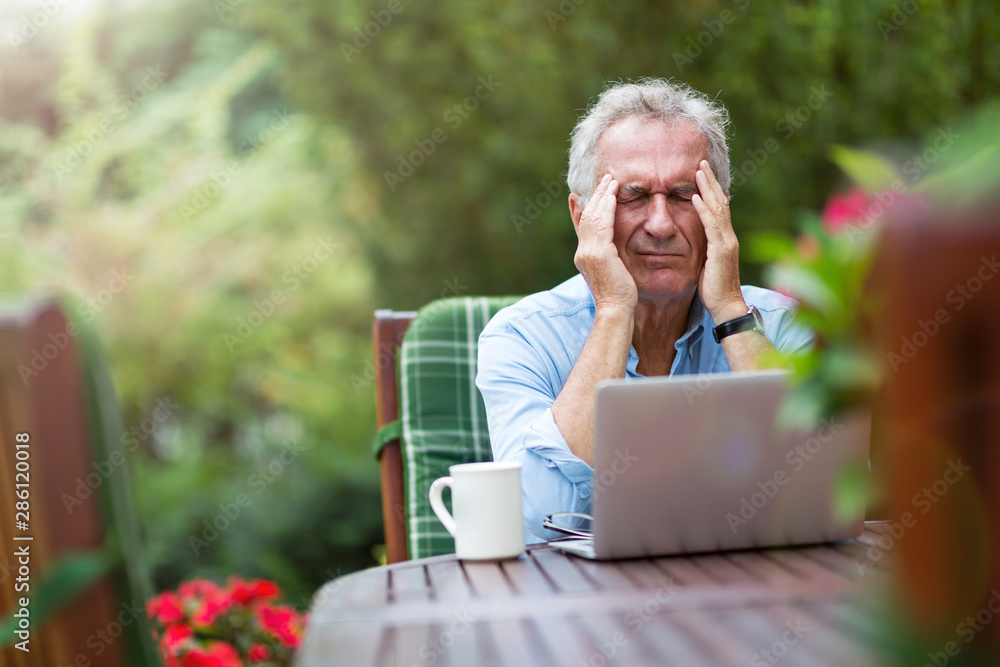 Obraz premium Senior man looking stressed while working on laptop 