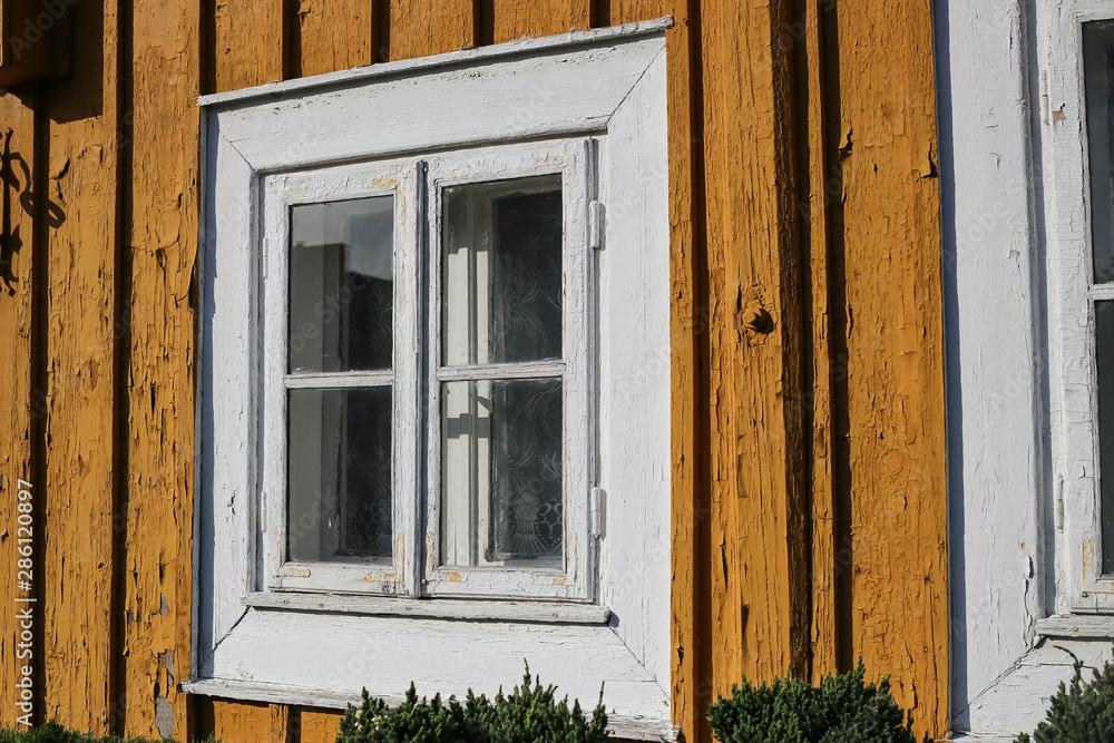 Yellow window wooden. Part of typical house in Lithuania, Trakai. Antique old house with yellow old wood Yellow window wooden. Part of typical house in Lithuania, Trakai. Antique old house with yellow old wood