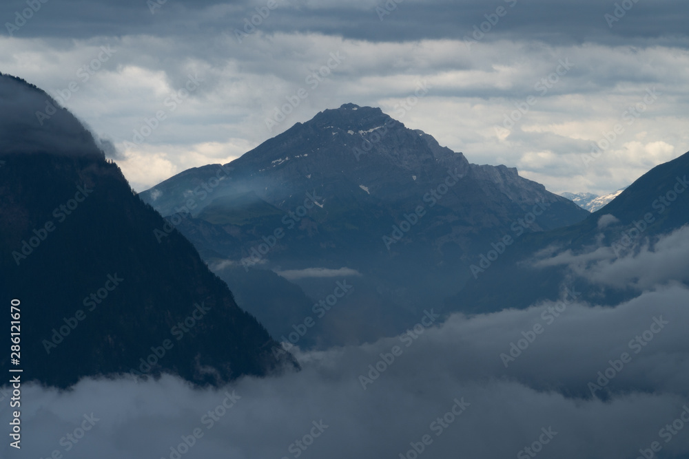 A mountain range in the clouds - blue colors