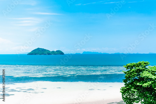 Beautiful blue seascape with a small island on the horizon © Irina