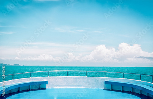 View from bow of white boat on blue sea and cloud sky by line of horizon
