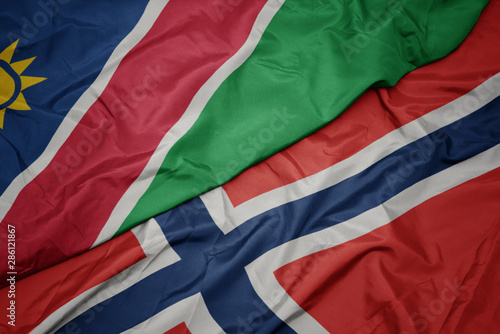 waving colorful flag of norway and national flag of namibia.