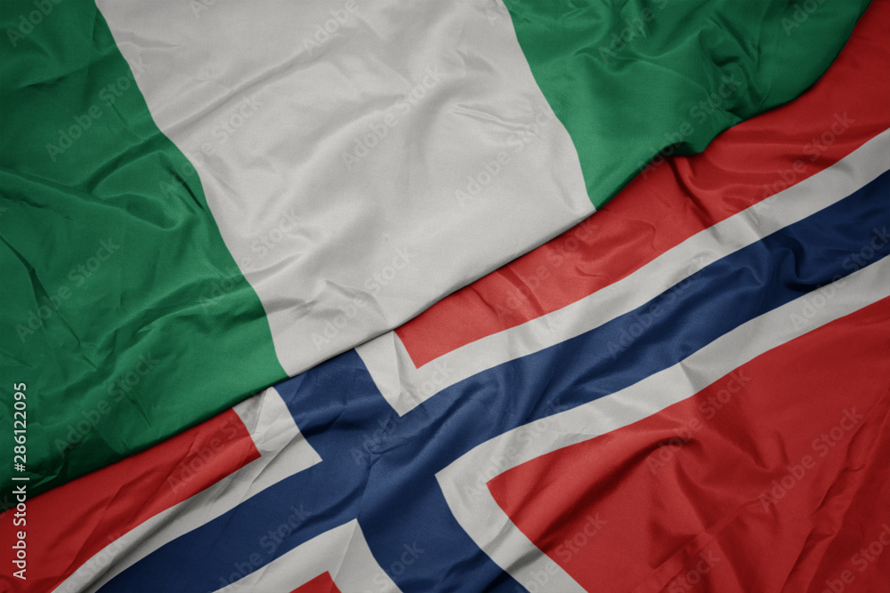 waving colorful flag of norway and national flag of nigeria.